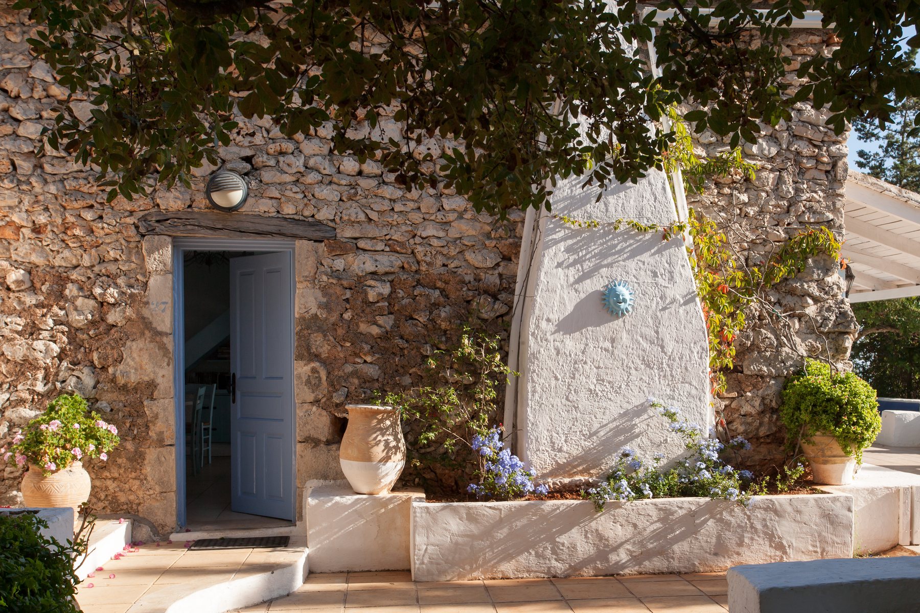 The stone entrance to Villa Galini, surrounded by olive trees
